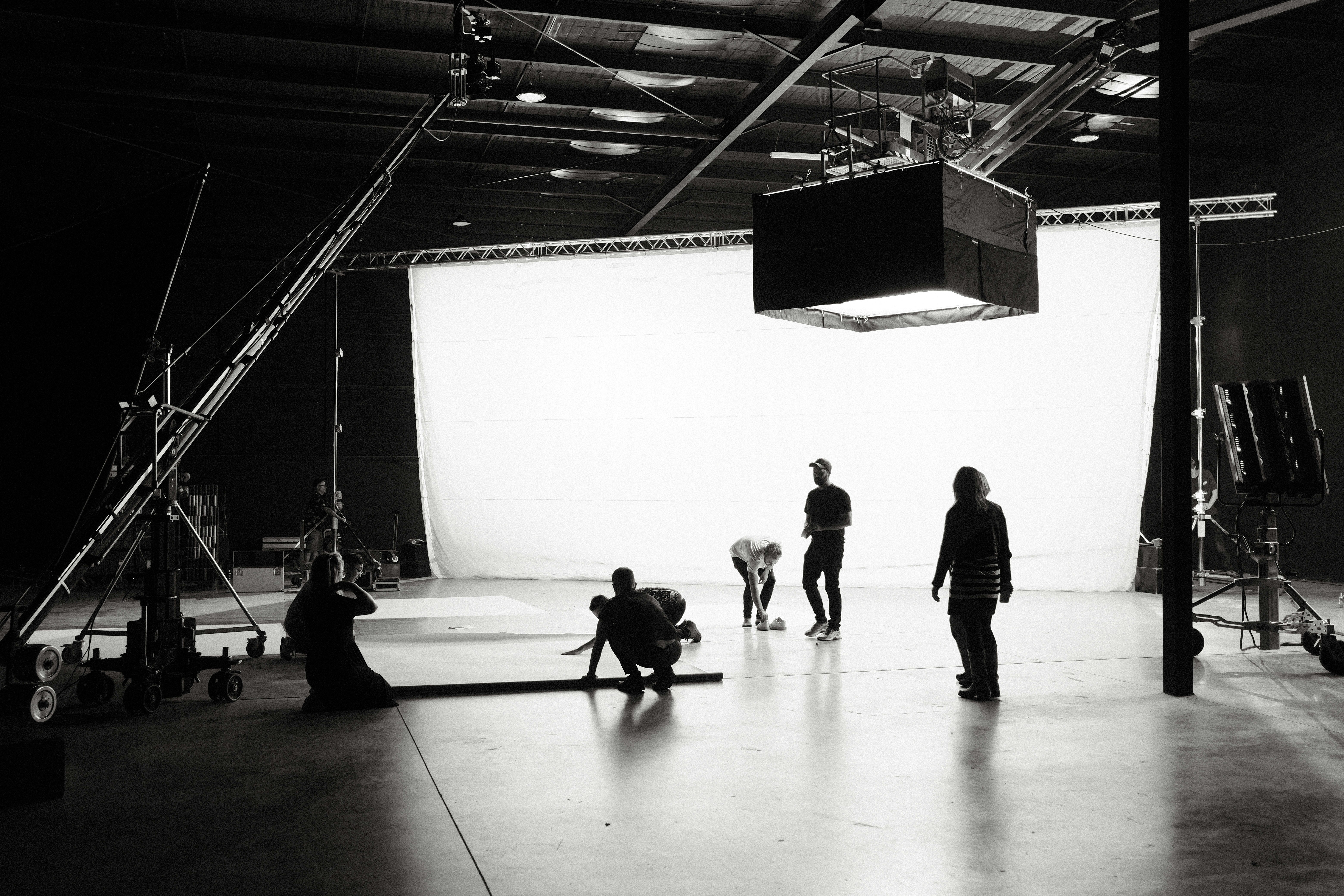 B&W Photo of silhouetted people setting up a theatre stage